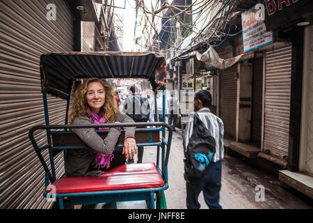 Un modèle féminin (touristique) parution sur un vélo rickshaw posant pour une photo de Chandni Chowk, l'un des plus grands marchés de gros de l'Inde à Delhi. Banque D'Images