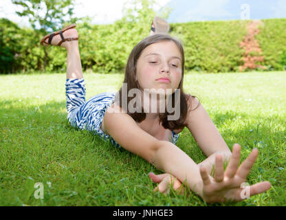 Pretty smiling pre teen girl lying in grass Banque D'Images