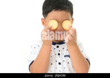 Petit garçon avec des yeux fermer cookie isolé sur fond blanc Banque D'Images