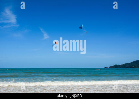 Personnes jouant le parachute ascensionnel sur la plage de Patong à Phuket, Thaïlande. Phuket est un mélange grisant de la ville animée de bars, boîtes de nuit, restaurants et véritablement spectaculaires Banque D'Images