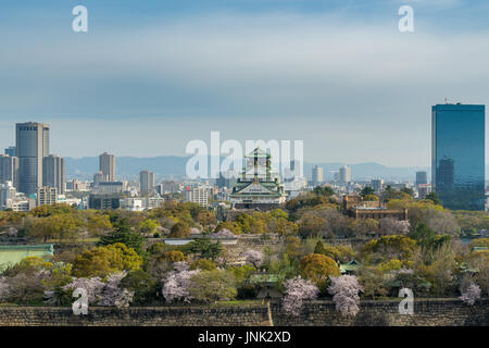 Le château d'Osaka avec fleur de cerisier et le centre d'affaires dynamique du contexte à Osaka, Japon. Le Japon printemps belle scène. Banque D'Images