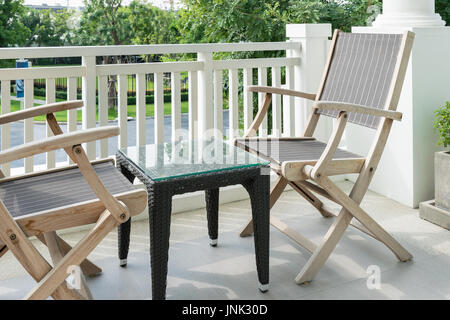 Des chaises en bois sur balcon donnant sur un jardin moderne Banque D'Images