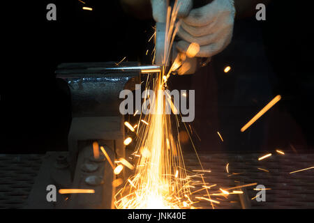 Worker cutting avec broyeur et le métal de soudure avec beaucoup d'étincelles sharp en usine Banque D'Images