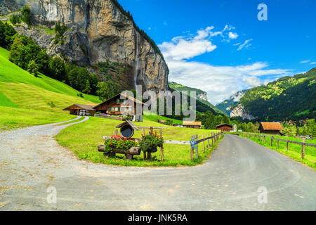 Ferme rurale suisse avec les pâturages, les champs verts et de grande cascade Staubach Lauterbrunnen en arrière-plan, ville touristique, Oberland bernois, Switzerl Banque D'Images