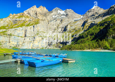 Amazing lac alpin et de superbes montagnes avec bateaux, bleu du lac Oeschinen, Oberland Bernois, Suisse, Europe Banque D'Images