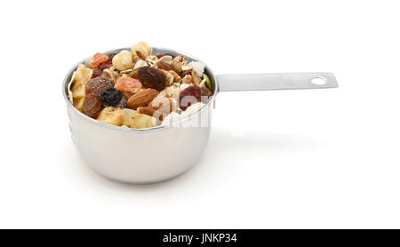 - Muesli céréales avec des graines, mélange de fruits et noix - dans une tasse mesure, isolé sur fond blanc Banque D'Images