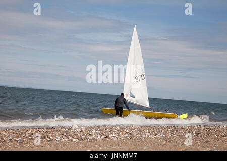Homme avec bateau à voile sur l'eau de la plage de sable d'Édimbourg, capitale de l'Ecosse, Royaume-Uni. Banque D'Images