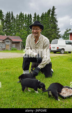 Saam agriculteur avec son renne de Laponie chien et chiots. La Laponie finlandaise Banque D'Images