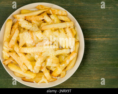 Bol de fromage grillé et frit jetons contre un fond de bois vert Banque D'Images