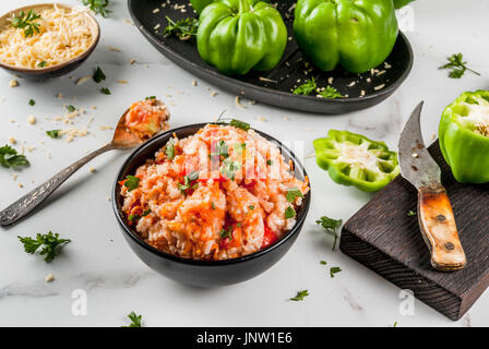 Recettes d'automne. Accueil poivron farci avec de la viande hachée, les carottes, les tomates, les herbes et le fromage. Processus de cuisson. Sur une table de marbre blanc. Copy space Banque D'Images