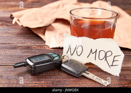 L'alcool dans le verre, des clés de voiture, papier message. Banque D'Images