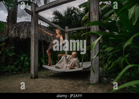 Closeup portrait of young couple contenu staing sur banc oscillante Banque D'Images