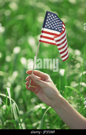 Human hand holding US flag pour le jour de l'indépendance Banque D'Images