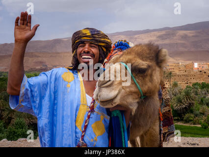 Un berber man smiling avec son chameau dans la vallée de Todra , Maroc Banque D'Images