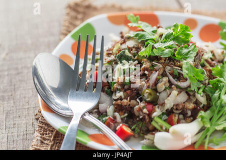 Oeufs épicés de ant la nourriture thaïe et une fourche sur sol en bois. Banque D'Images