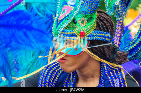 Interprète féminine portant un costume coloré, coiffe et masque sur les rues d'Édimbourg dans le carnaval de la Jazz and Blues Festival Banque D'Images