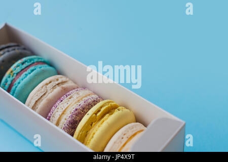 Beaucoup de beaux macarons. Vue d'en haut. Dans l'encadré sur un fond bleu Banque D'Images