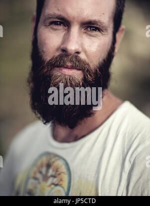 Portrait d'homme barbu portant des T-shirt imprimé, looking at camera. Banque D'Images