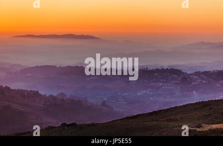 Paysage avec le Ciel de coucher du soleil au-dessus de couches de foggy mountains Banque D'Images