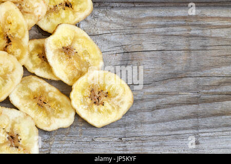 Des chips de banane (séché et rondelles de banane frites) sur fond de bois. Top View with copy space Banque D'Images