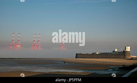 Grues à quai géant au Seaforth container terminal sortant de la brume derrière Fort Perchaude Rock, New Brighton Banque D'Images