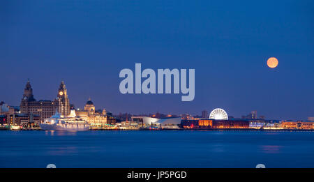 Lune sur Liverpool waterfront. Une lune orange ajoute de l'intensité à ce panorama de l'Liverpool skyline at night. Banque D'Images