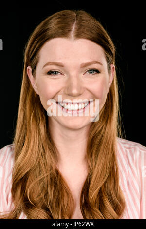 Portrait de belle jeune femme rousse looking at camera isolated on black Banque D'Images