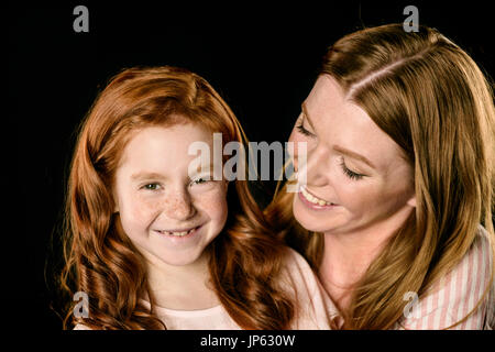 Close-up portrait of smiling mother looking at adorable fille rousse Banque D'Images