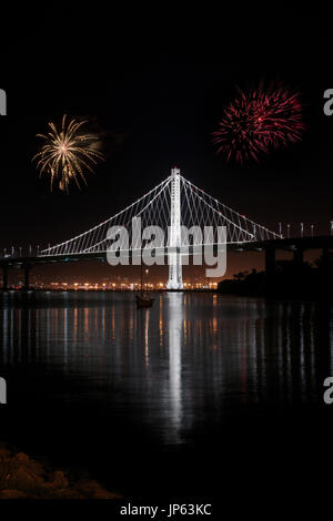 New East Span Bay Bridge illuminé la nuit, reflétant les lumières de couleur. Et l'emblématique pont après la tombée de la majestueuse vue de Treasure Island à San Fran Banque D'Images