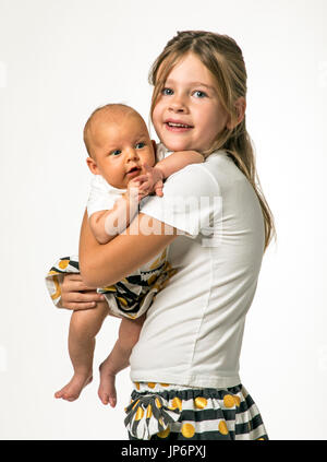 Portrait de studio de 7 ans girl holding 7 bébé de la semaine Banque D'Images