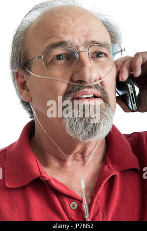 Vieil homme avec la MPOC à parler au téléphone tout en portant une canule pour l'oxygène de l'air supplémentaire. Banque D'Images