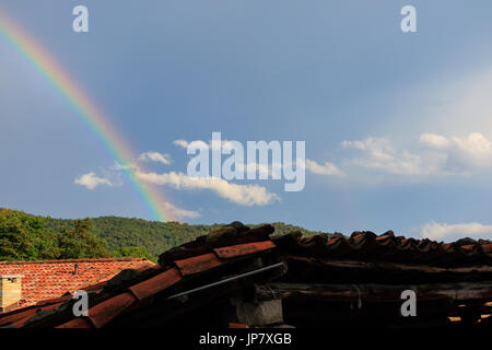 Scène avec arc-en-ciel, phénomène naturel ciel bleu au-dessus d'une forêt d'arbres dans les montagnes Banque D'Images