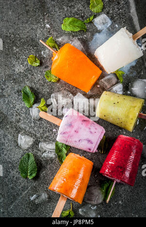 Desserts d'été en bonne santé. Sucettes glacées crème glacée. Des smoothies, des jus tropicaux congelés myrtilles. de Corinthe, orange, mangue, kiwi, banane, noix de coco, framboise Banque D'Images