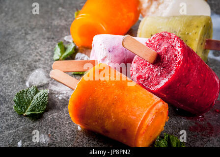 Desserts d'été en bonne santé. Sucettes glacées crème glacée. Des smoothies, des jus tropicaux congelés myrtilles. de Corinthe, orange, mangue, kiwi, banane, noix de coco, framboise Banque D'Images