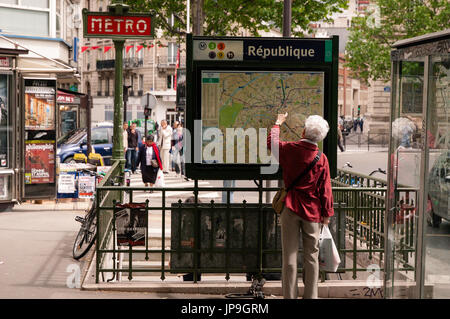 Dame de vérifier le plan du métro à l'entrée de la station de la République à Paris France Banque D'Images