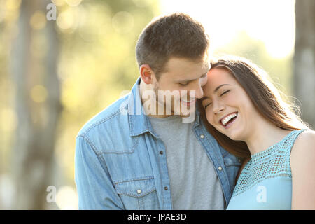 Affectionate couple amoureux rire dans un parc Banque D'Images