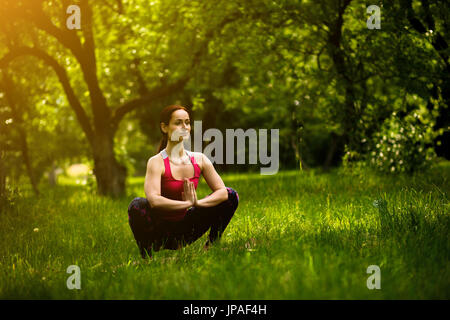 Woman practicing yoga se concentrant dans Garland poser. Banque D'Images