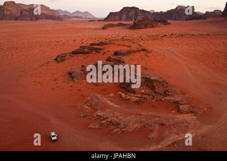 Une jeep blanche parking dans le désert rouge du wadi Rum en Jordanie. Banque D'Images