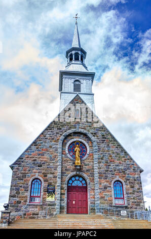 Les Eboulements, Canada - 2 juin 2017 : presbytère de l'église des éboulements dans Charlevoix, région de Québec avec l'architecture en pierre colorée et ciel bleu Banque D'Images