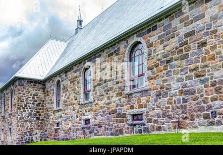 Les Eboulements, Canada - 2 juin 2017 : presbytère de l'église des éboulements dans Charlevoix, région de Québec avec l'architecture en pierre colorée et ciel bleu Banque D'Images