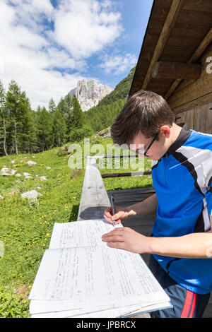 L'Europe, Italie, Vénétie, San Tomaso Agordino, Dolomites, randonneur tout en signant le livre sur le bivouac Col Mandro, groupe Civetta Banque D'Images