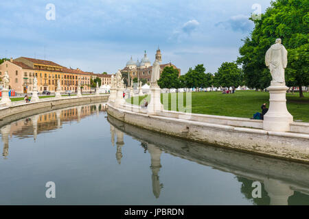 Statues ressortir dans l'canal elliptique entourant les jardins sur Prato della Valle, Padoue, Vénétie, Italie sur une journée nuageuse avec des bâtiments historiques de l'arrière-plan, l'Italie, l'Europe Banque D'Images