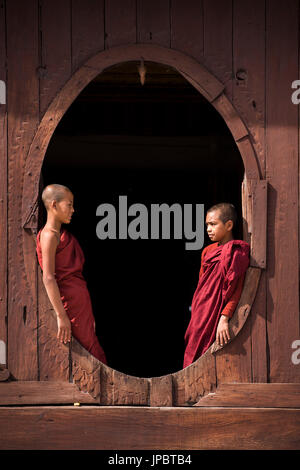 Nyaungshwe, lac Inle, l'État de Shan, Myanmar. Les moines novices au Shwe Yaunghwe Kyaung par les fenêtres de l'hôtel de coordination en teck Banque D'Images