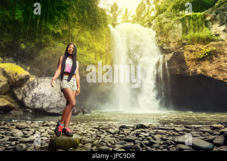 Jeune femme voyage backpacker profitez d'une vue imprenable sur la cascade tropicale cachée dans la jungle. Concept d'Écotourisme Voyage fille image Banque D'Images