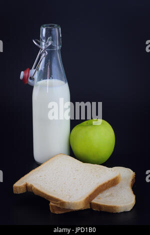 Petit-déjeuner de l'énergie pour l'alimentation du pain, du lait et de pomme verte sur fond noir Banque D'Images