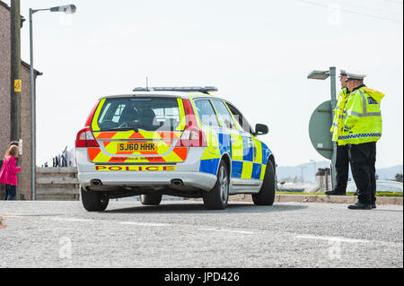 Castle Douglas, ÉCOSSE - 25 Avril 2011 : des agents du trafic, se tenir à côté d'une voiture de police qui est utilisé comme un barrage routier. La route était fermée Banque D'Images