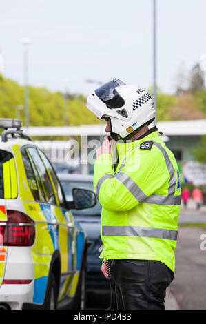 Castle Douglas, ÉCOSSE - 25 Avril 2011 : un officier de police de la circulation à l'aide de sa radio. Le policier faisait partie d'un groupe de policiers qui escortaient une course. Banque D'Images