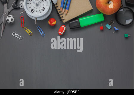 Haut afficher les accessoires retour à l'école ou de bureau articles de fond de bureau.Variété papeterie sur grunge blackboard with copy space pour des maquettes et nous Banque D'Images