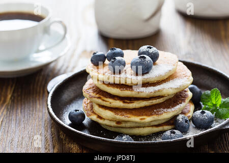 Crêpes au babeurre de bleuets dans poêle en fonte servi chaud sur table en bois rustique, petit-déjeuner sain Banque D'Images