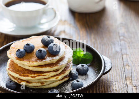 Crêpes au babeurre de bleuets dans poêle en fonte servi chaud sur table en bois rustique, petit-déjeuner sain Banque D'Images